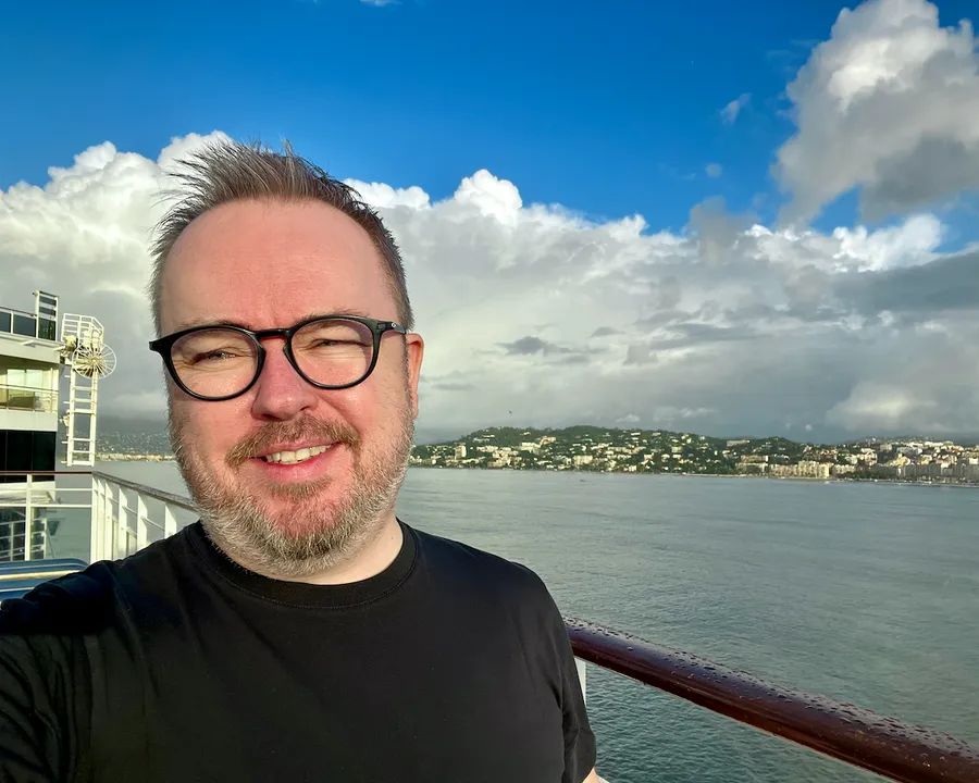Patrick Hughes aboard the Norwegian Epic cruise ship with Cannes in the background